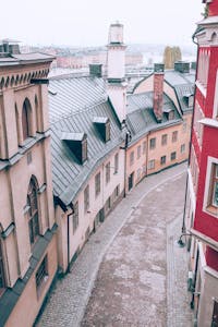 From above of old stone residential buildings located on narrow paved street in European city