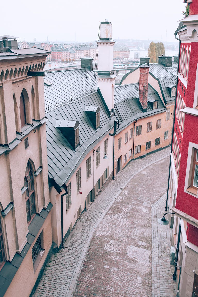 From above of old stone residential buildings located on narrow paved street in European city